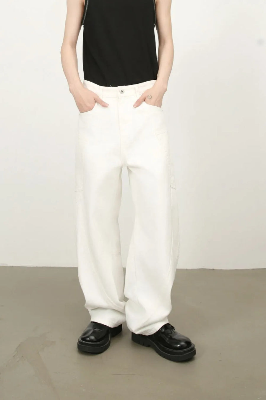 White wide leg trousers with sculpted pocket details and a relaxed fit.