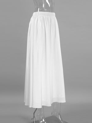 White high-waisted maxi skirt with elastic waistband and flowy silhouette.