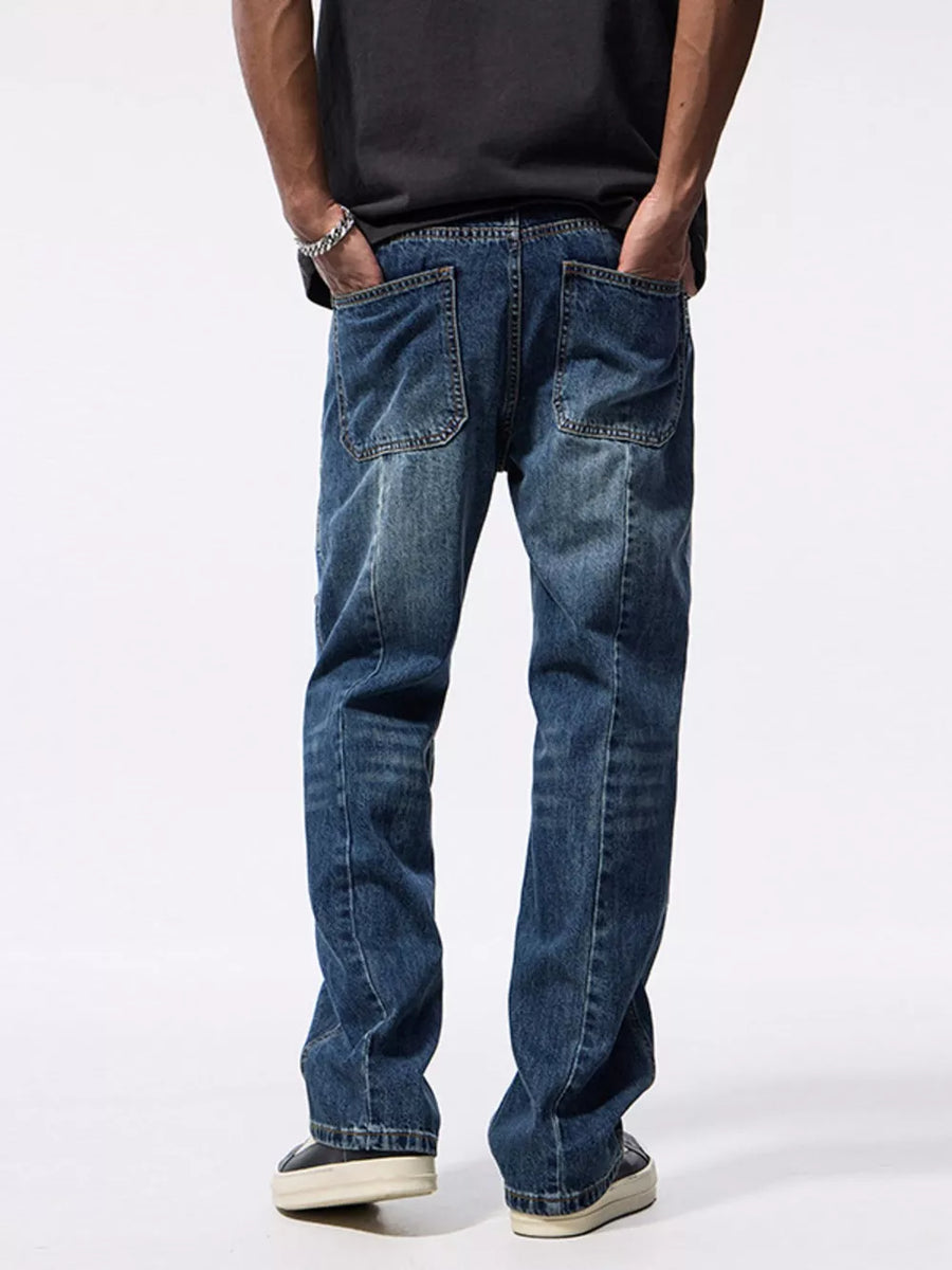 Relaxed fit blue denim jeans with patchwork details and distressed wash.