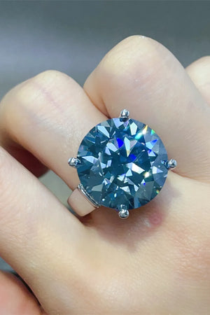 Royal blue moissanite cocktail ring with a large, round-cut center stone on a silver band.