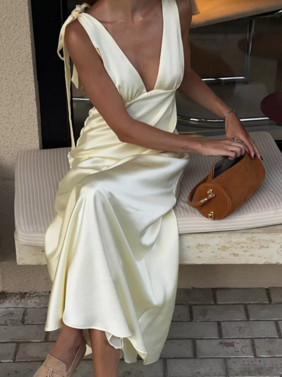 Satin slip dress in pale yellow with deep V-neck and tie shoulder straps.