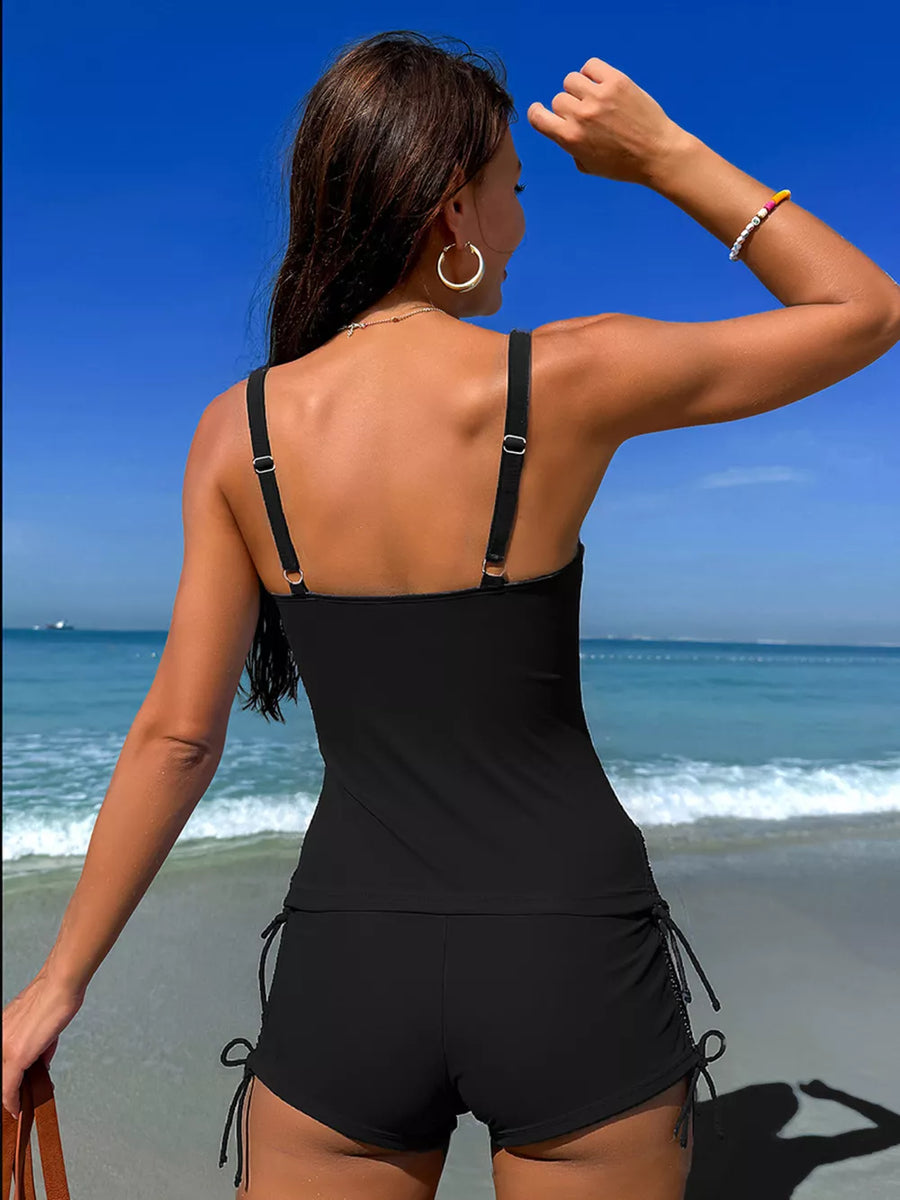 Black tankini top with adjustable straps and drawstring shorts.