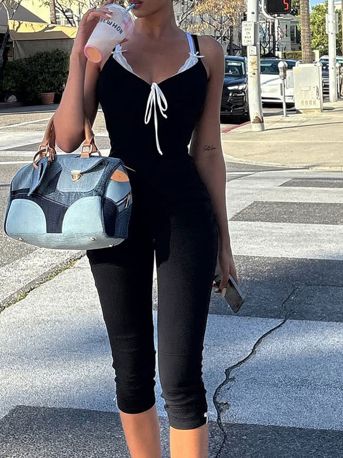 Black lace trim tie-front capri romper with white lace trim and bow detail.