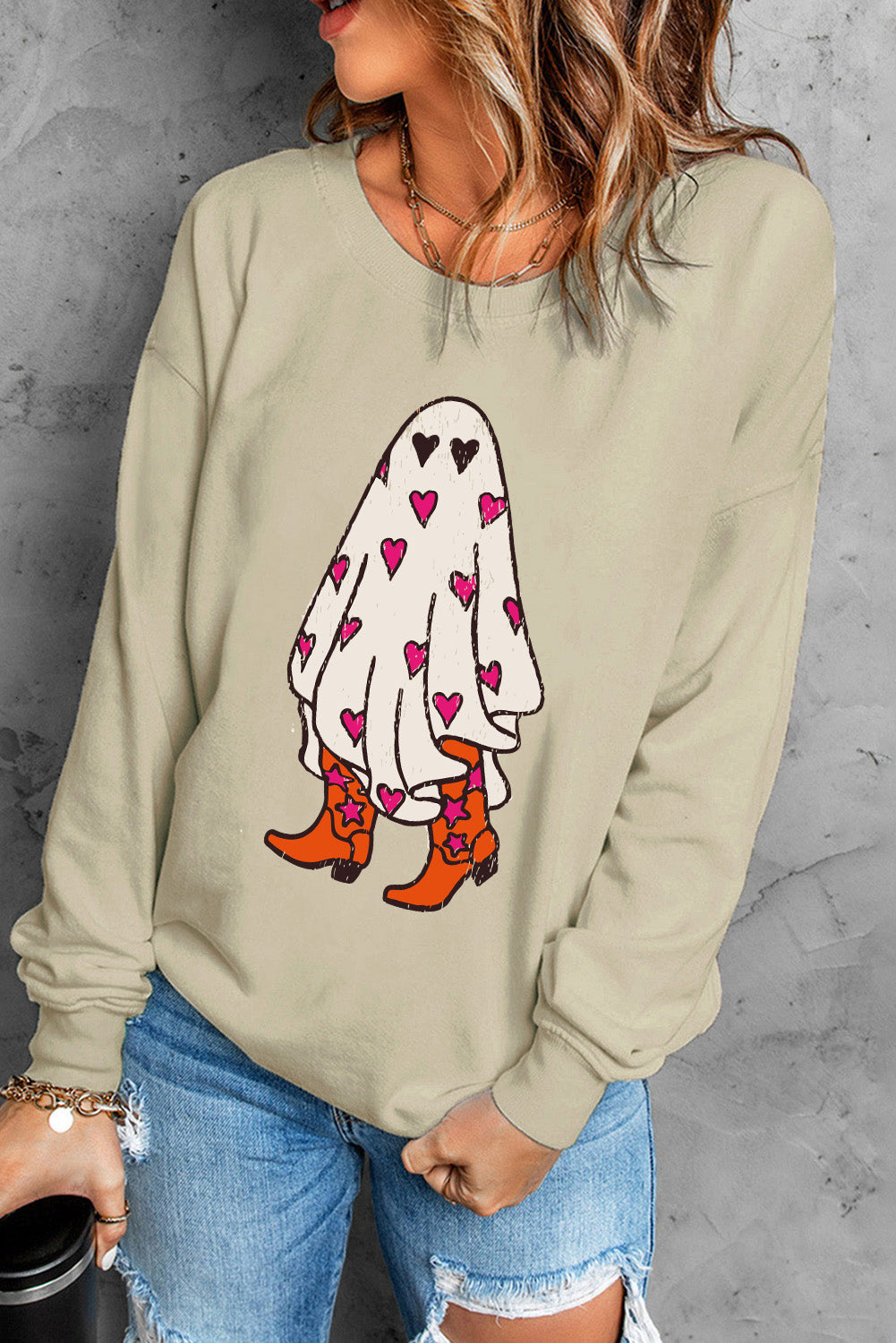 Beige crewneck sweatshirt with a graphic of a ghost wearing cowboy boots and covered in hearts.