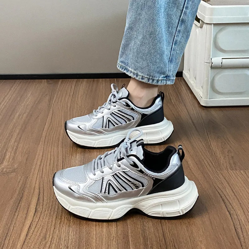 Chunky silver mesh runner sneakers with black accents and thick white soles.
