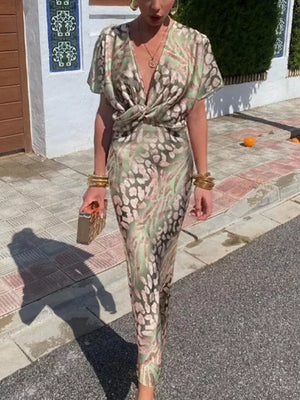 Twist-front animal print maxi dress with deep V-neck and short sleeves in green and pink.