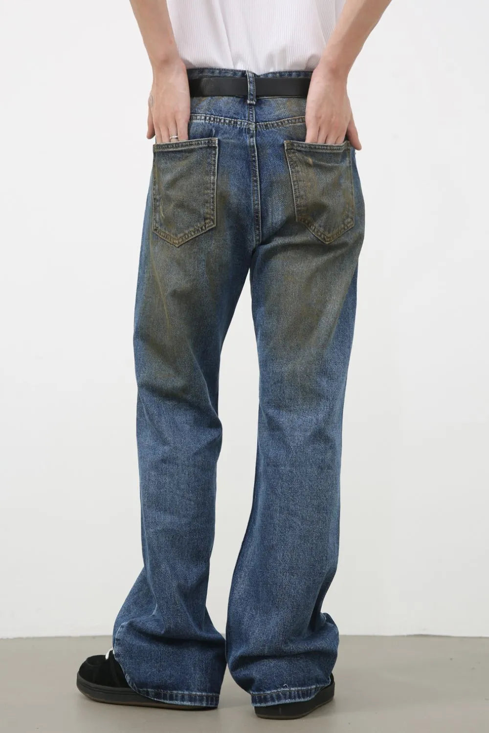 Distressed flare jeans in medium wash denim with patina effect on back pockets.