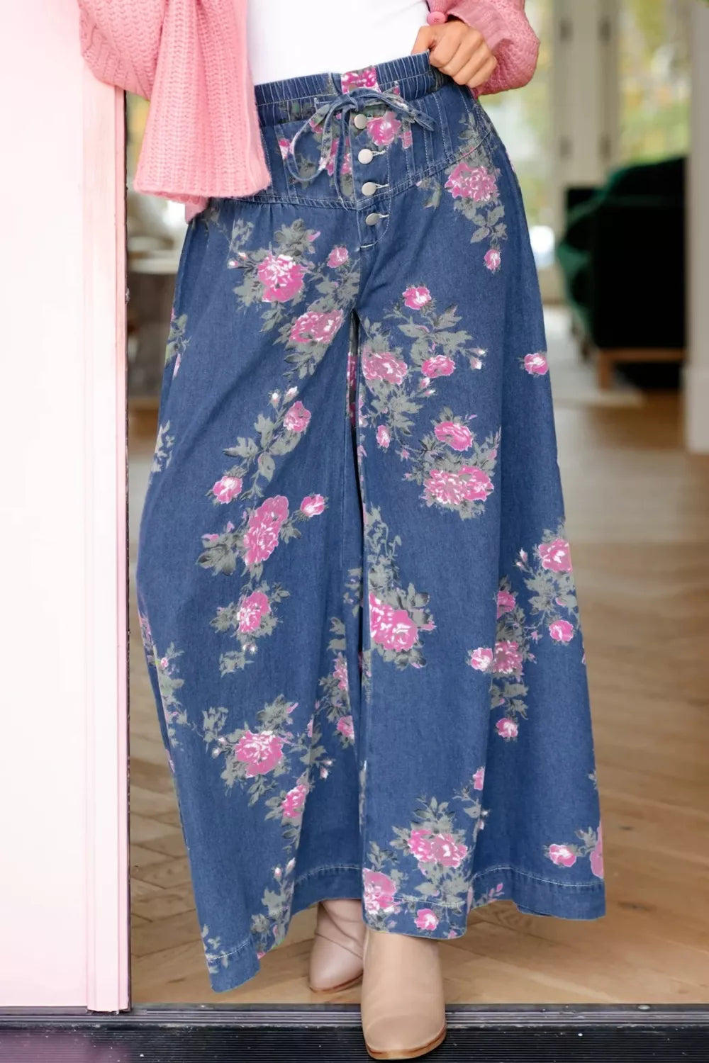 Floral print denim wide-leg jeans with button-front and tie waist.