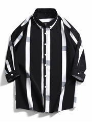 Oversized button-up shirt in black with white and grey stripes and plaid accents.