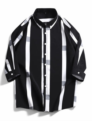 Oversized button-up shirt in black with white and grey stripes and plaid accents.