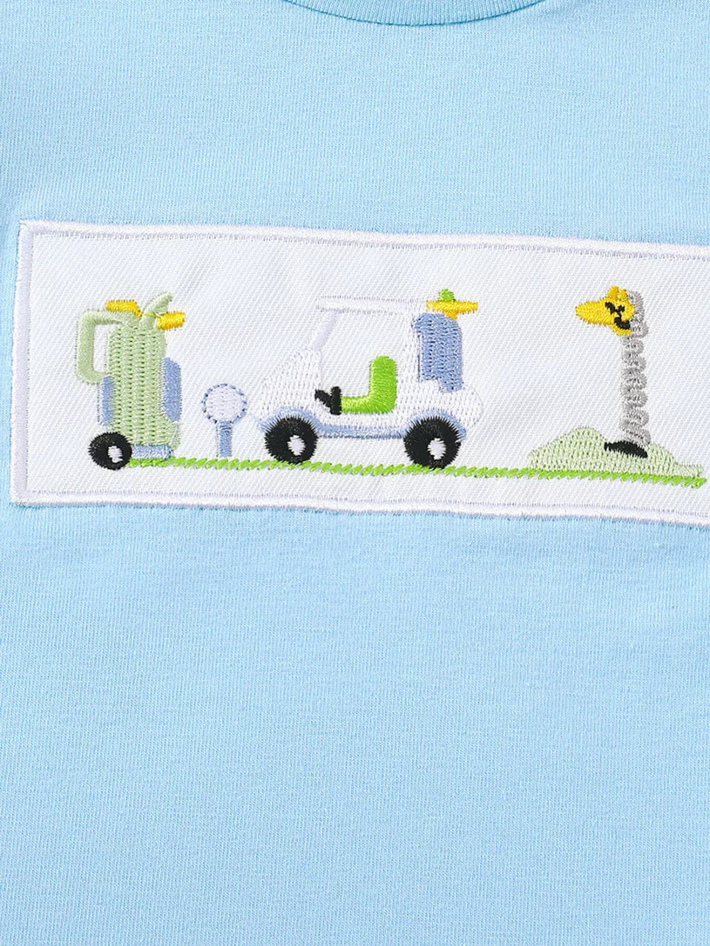 Light blue cotton tee with embroidered golf cart, golf bag, and giraffe flag detail.