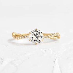 Gold twisted pavé zircon engagement ring with a round center stone.