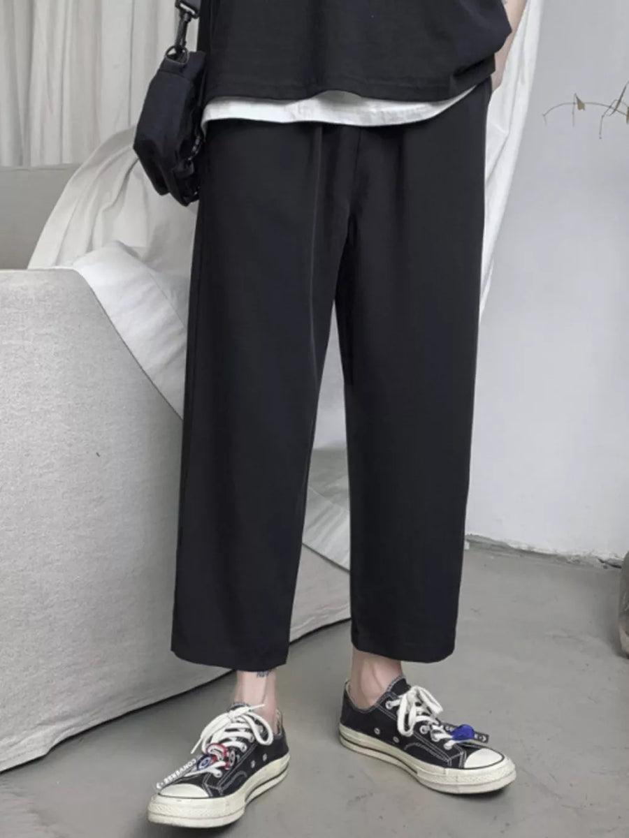 Black relaxed fit cropped sweatpants with drawstring waist and wide leg.
