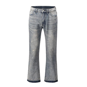 Distressed wash bootcut jeans with raw hem in medium blue denim, featuring paint splatters and whiskering.