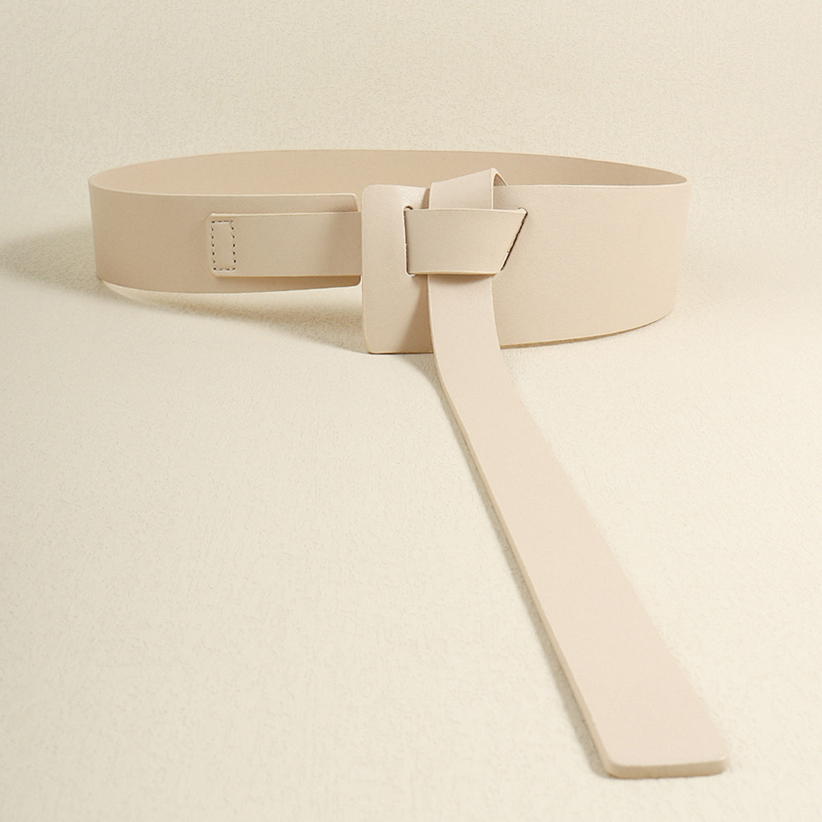 Ivory leather belt with a knotted, elongated tail and a square buckle detail.