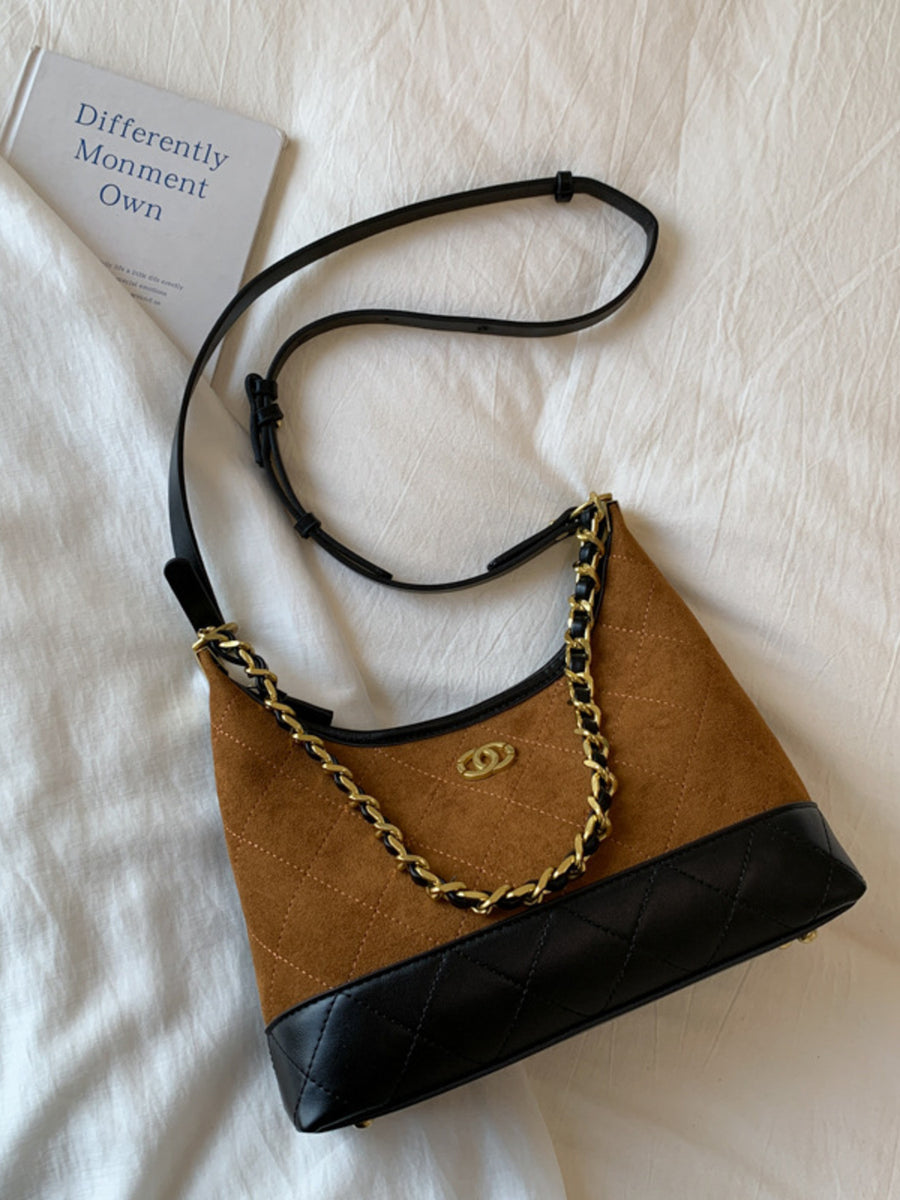 Brown half-moon crossbody bag with quilted black trim and gold chain detail