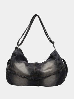 Frayed denim slouch crossbody bag in dark wash with distressed details.