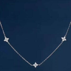 Sterling silver necklace with three delicate clover charms, each with sparkling stones.