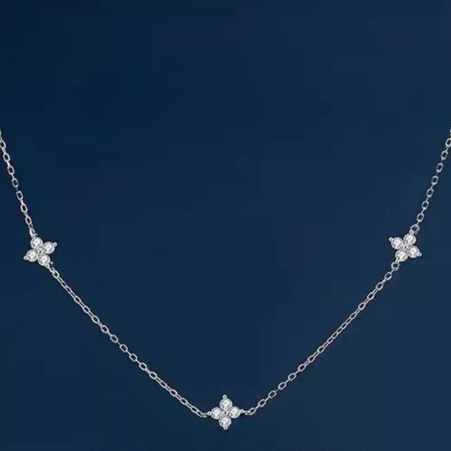 Sterling silver necklace with three delicate clover charms, each with sparkling stones.