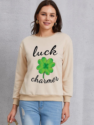 Khaki crewneck sweatshirt with green shamrock graphic and "luck charmer" text.