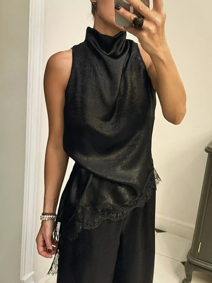 Black asymmetrical cami top with lace trim and mock neck.