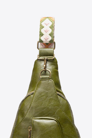 Green textured sling bag with woven strap detail and adjustable strap.