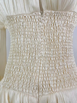 White cotton mini dress with corset waist and ruffled details.