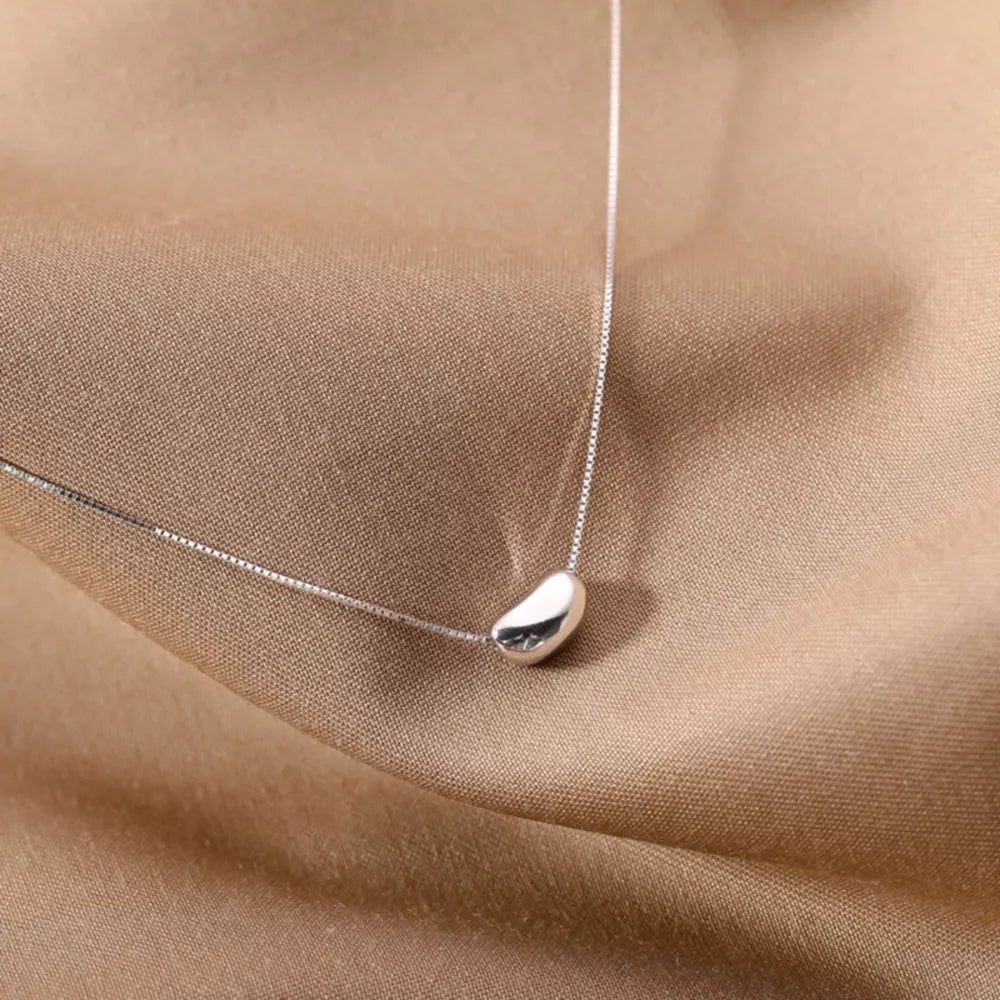 Sterling silver bean pendant necklace with a delicate box chain.