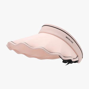 Scalloped brim sun visor in blush pink with black trim and adjustable strap.