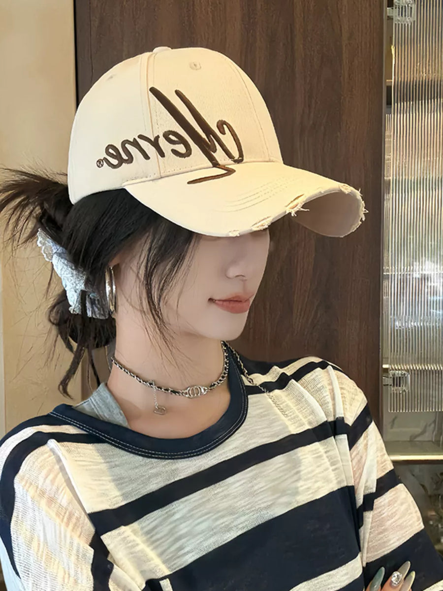 Off-white cotton baseball cap with distressed brim and embroidered detail