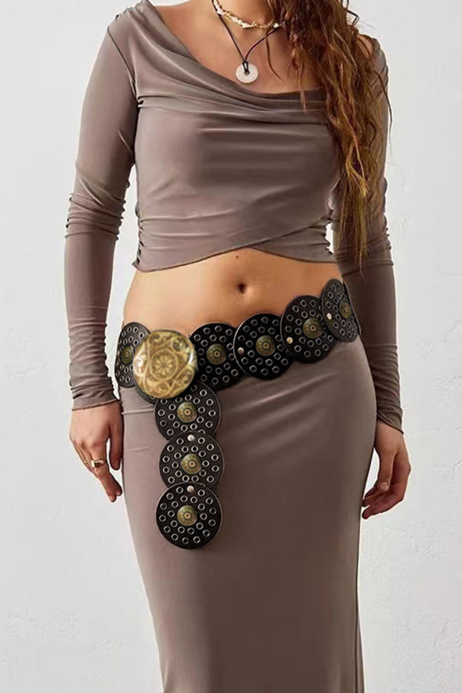 Disc-embellished statement belt in black with gold accents and a large decorative buckle.