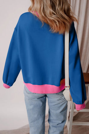Varsity sweatshirt in peacock blue with pink colorblock trim and cuffs.