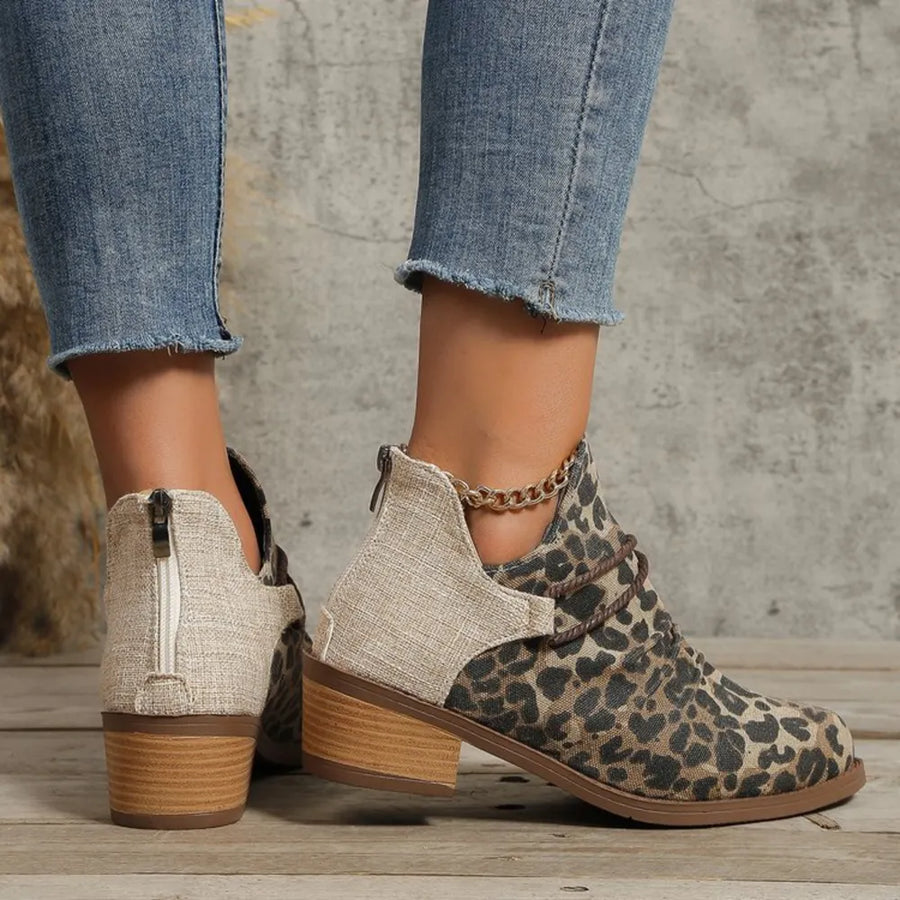 Leopard print ankle boots with cutout sides, chain detail, and back zipper.
