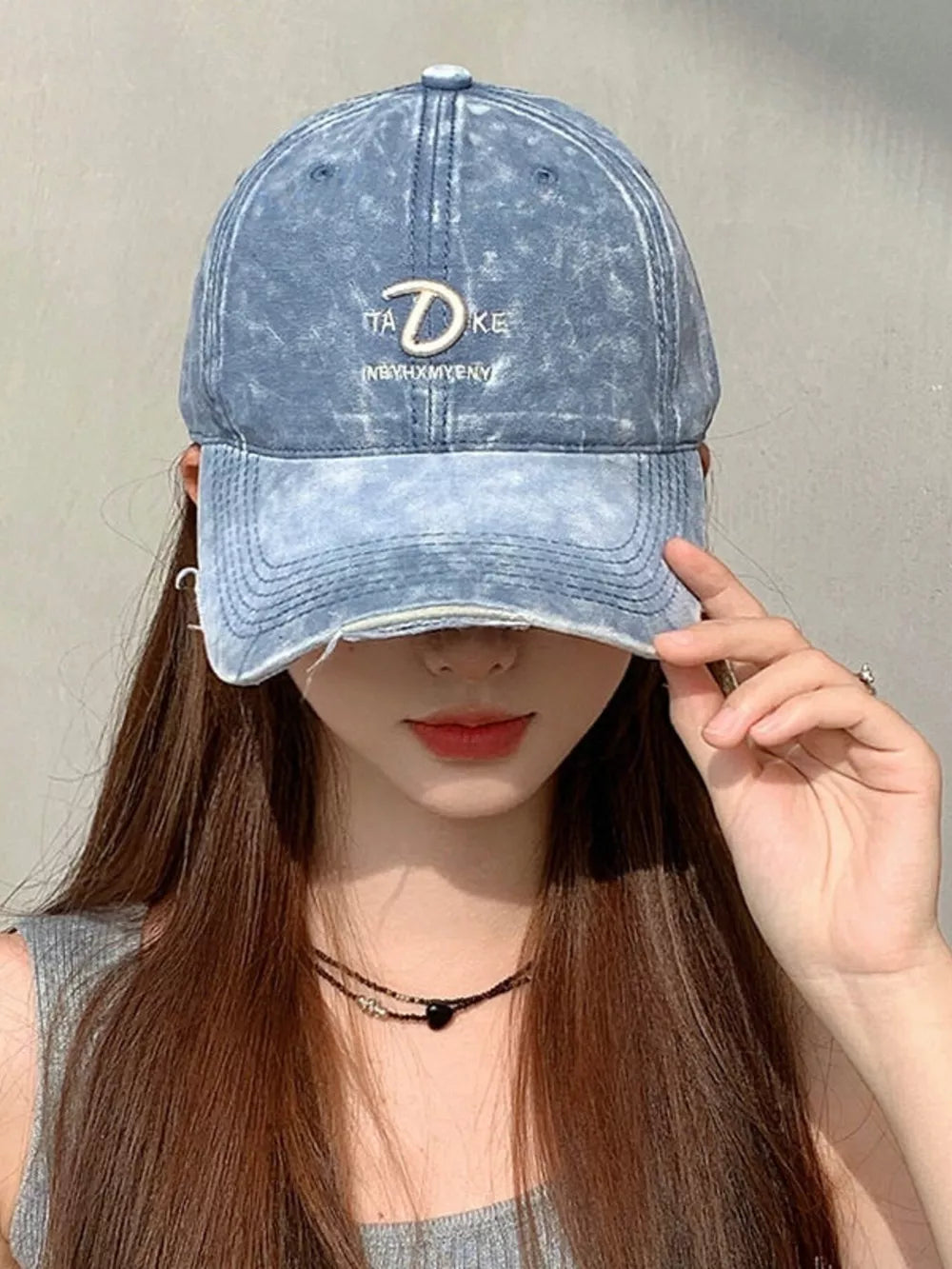 Blue denim baseball cap with embroidered text and distressed brim