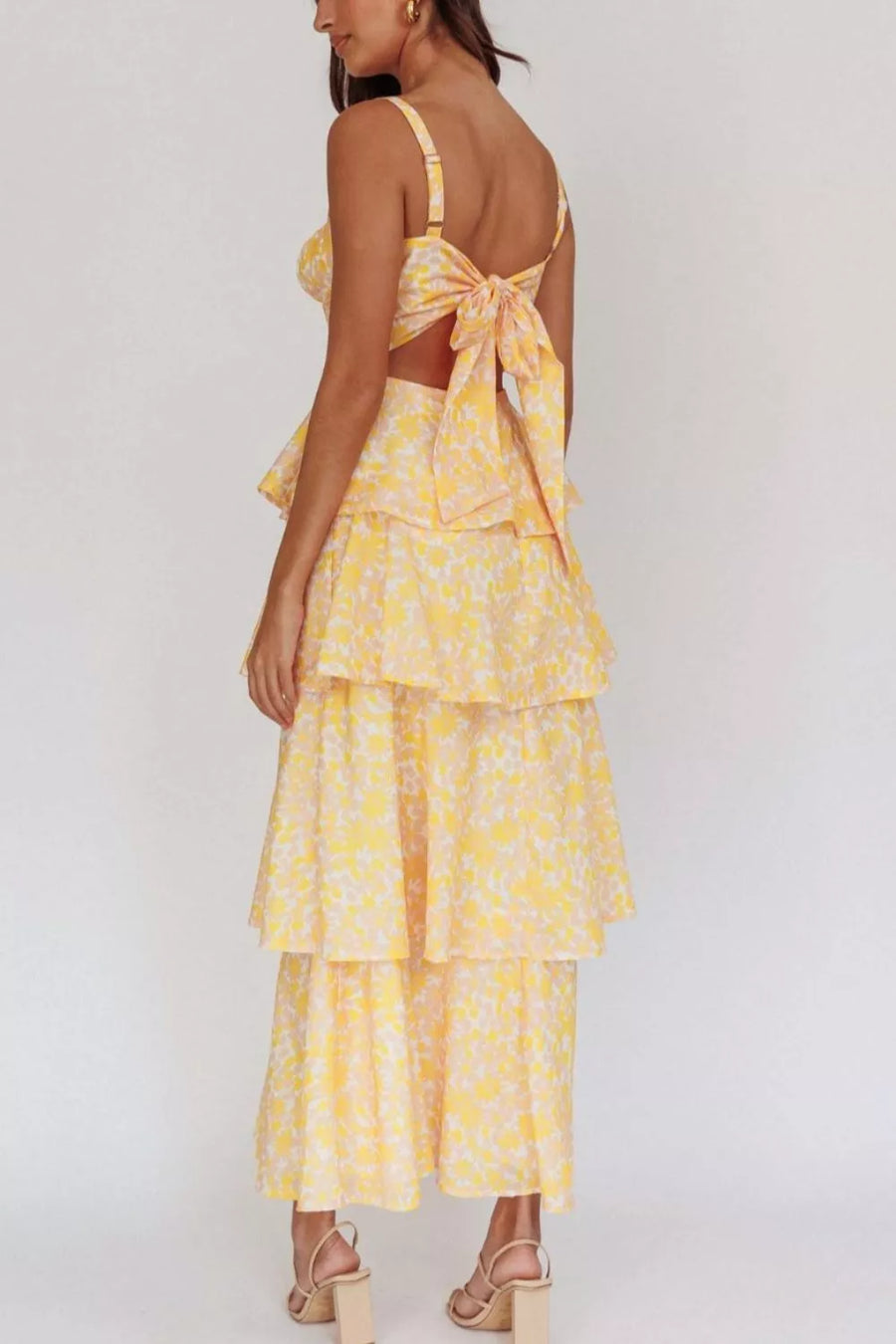 Yellow floral print tiered maxi dress with a tie-back crop top and cutout detail.