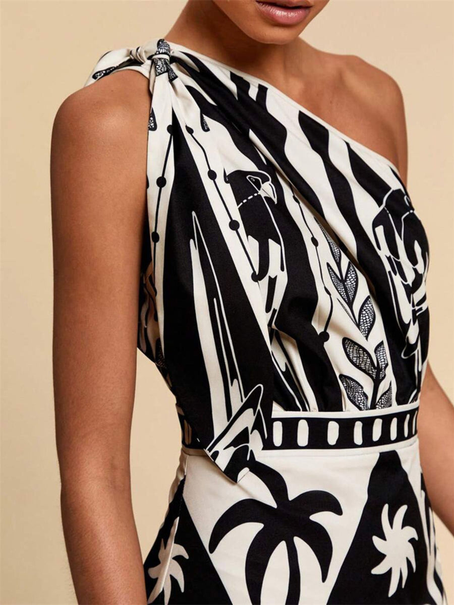 Black and white tropical print one-shoulder midi dress with defined waist and knot detail.
