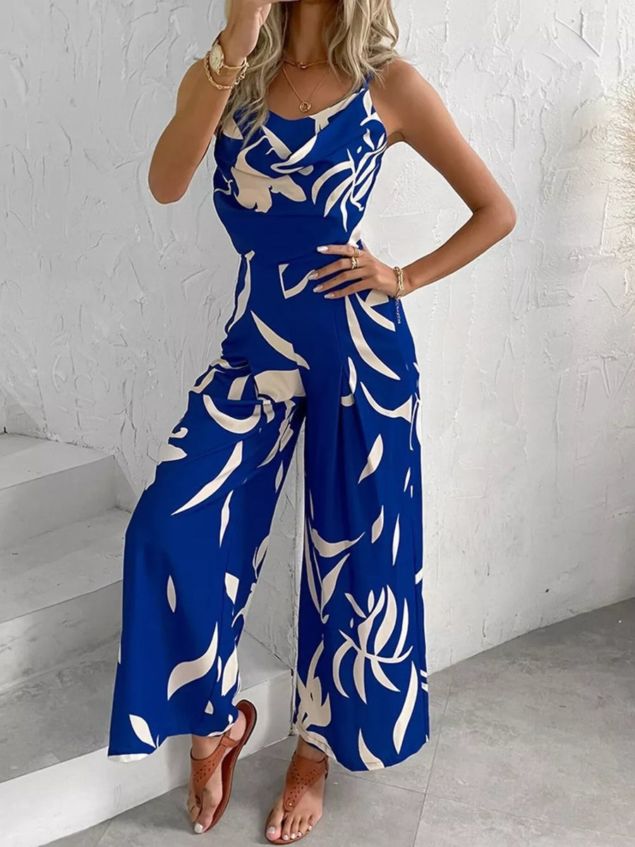 Royal blue abstract leaf print wide-leg jumpsuit with cinched waist and cowl neck.