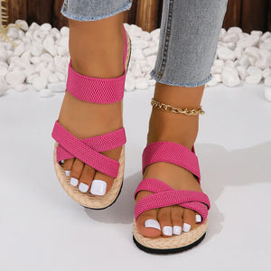 Hot pink woven sole crossover sandals with elastic straps and braided espadrille sole.