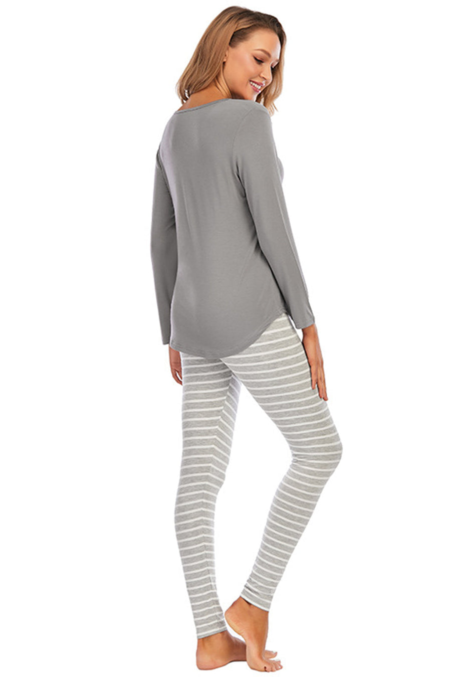 Charcoal long sleeve top and striped lounge pants on a woman.