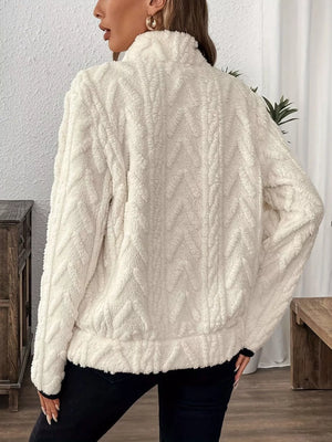 White sherpa half zip sweatshirt with chevron pattern and mock neck.