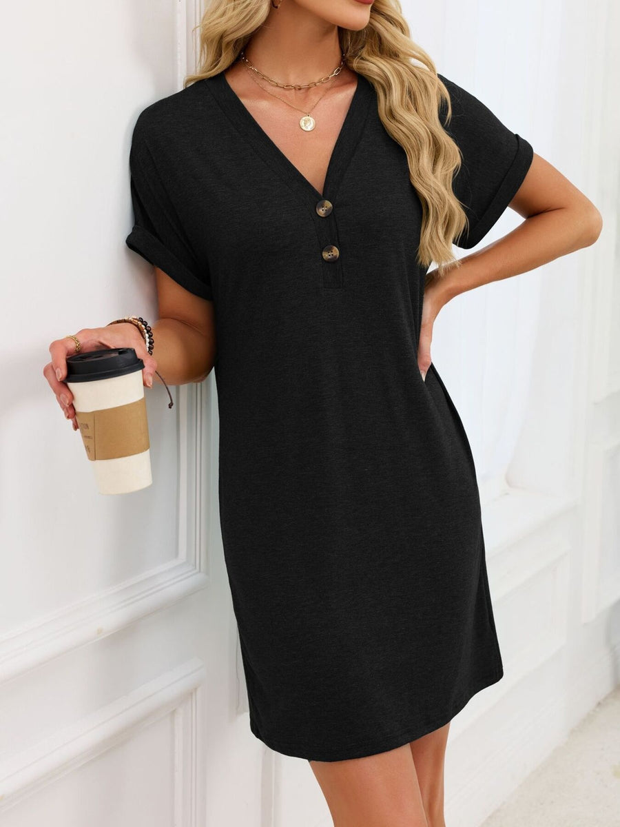 Black t-shirt dress with V-neck, short rolled sleeves, and decorative buttons.