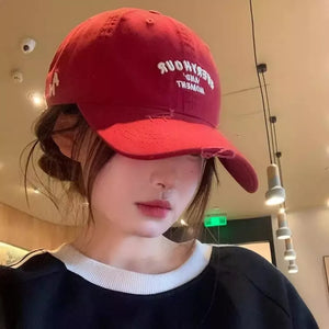 Burgundy distressed embroidered baseball cap with white text detail.
