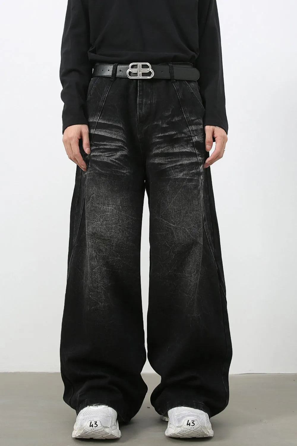 Faded black distressed denim palazzo jeans with a wide leg and a high waist.