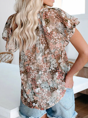 Floral print v-neck blouse with flutter sleeves and tie detail in a brown multi-color floral pattern.