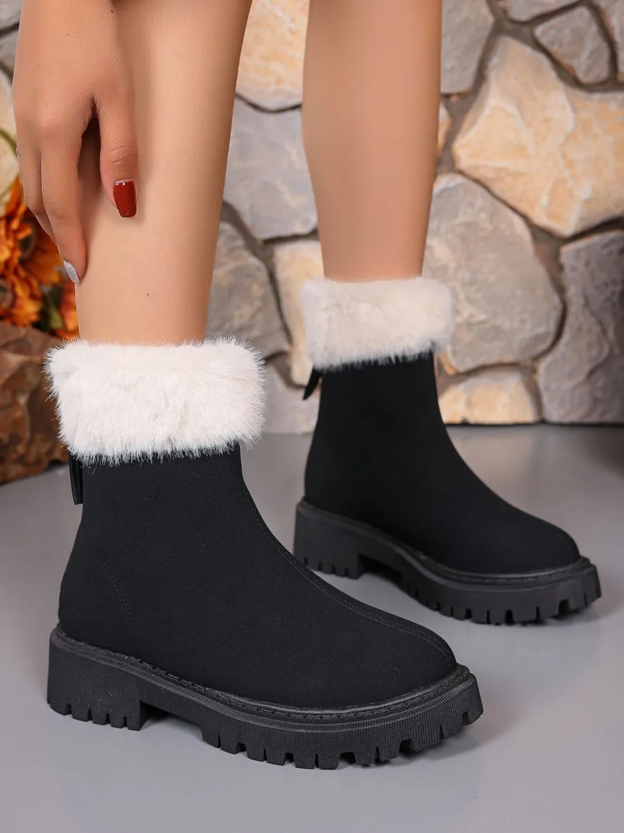 Black suede ankle boots with white faux fur trim and lug sole.