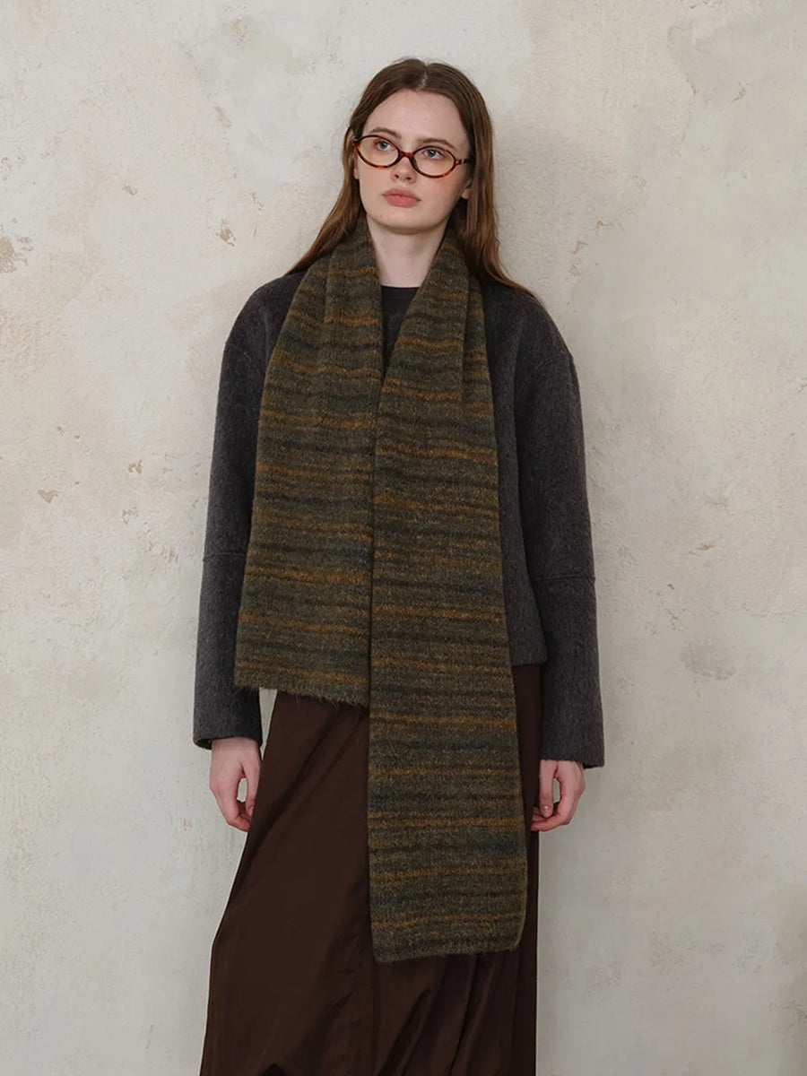 Textured mélange knit scarf in Olive with horizontal stripes, worn by a model.