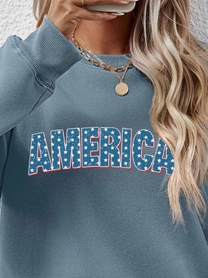 Misty Blue graphic crewneck sweatshirt with AMERICA text in distressed stars and stripes pattern
