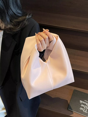 Blush pink leather shoulder bag with knot handle and classic carryall shape