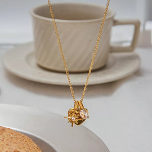 Gold heart charm necklace with crystal accent and starburst detail