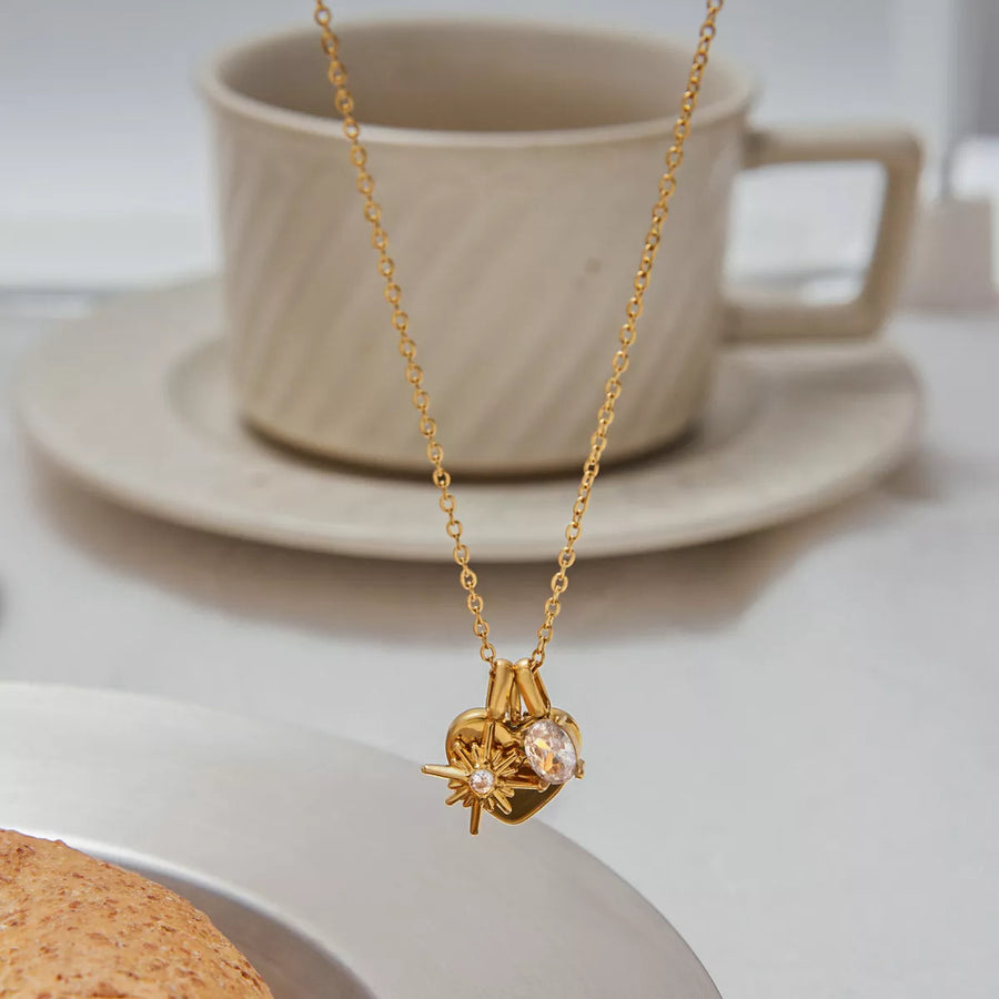 Gold heart charm necklace with crystal accent and starburst detail